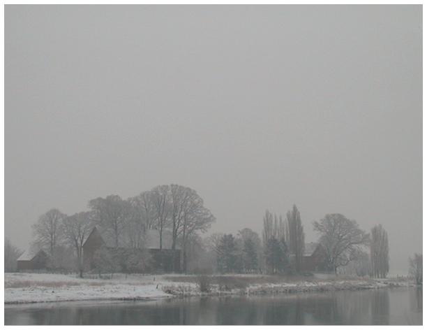 Blick auf das alte Fhrhaus auf der gegenberliegenden Weserseite von Petershagen. Es schneit. 